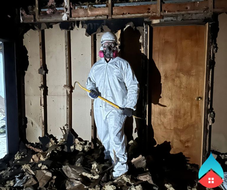Restoration technician documenting water damage for an insurance claim.